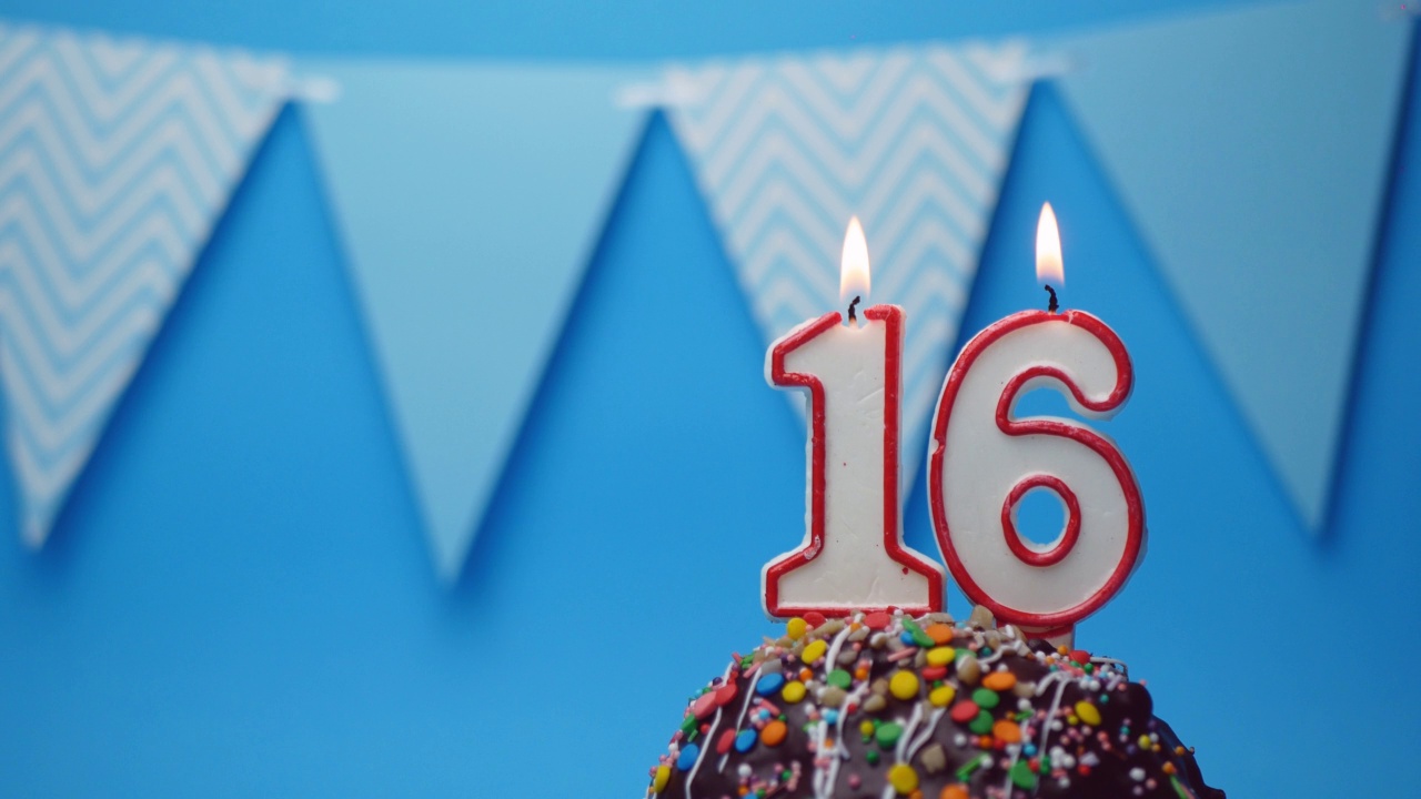 生日快乐的问候。16岁，小蛋糕，蓝色背景的生日蜡烛蛋糕。副本的空间。文本的地方视频下载