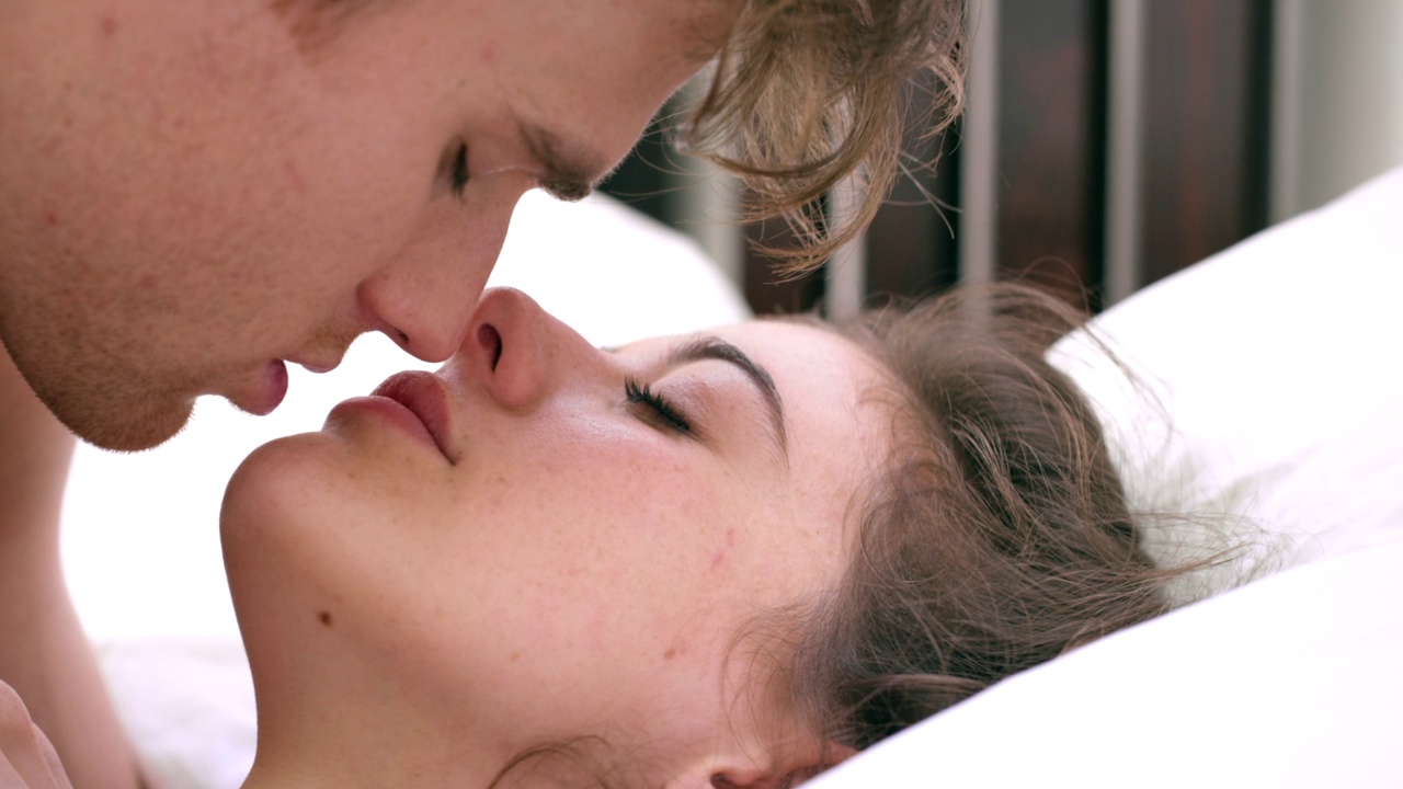 一对年轻夫妇在家里的床上接吻的4k视频视频素材