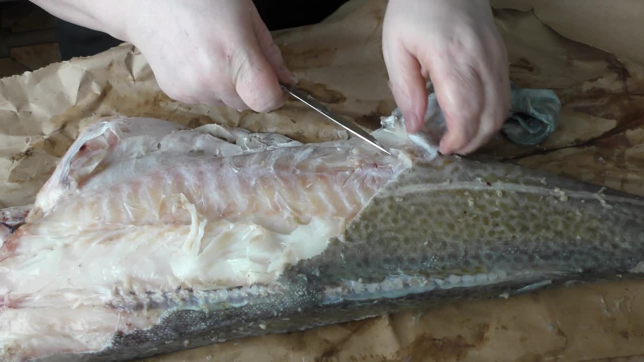 厨师把生鳕鱼切成块。视频下载