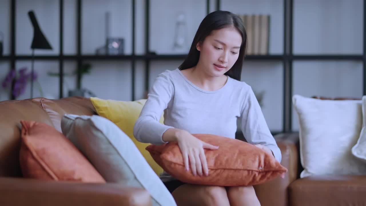 家庭主妇家庭工作家务观念，亚洲女性在休闲布整理靠垫，家居，家装和清洁观念-妇女在扶手椅和沙发上整理靠垫视频下载