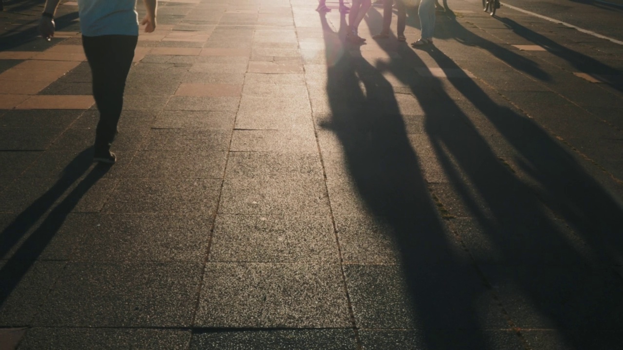 脚的剪影，人们在街上跳舞和行走。阳光灿烂的日子里走视频素材