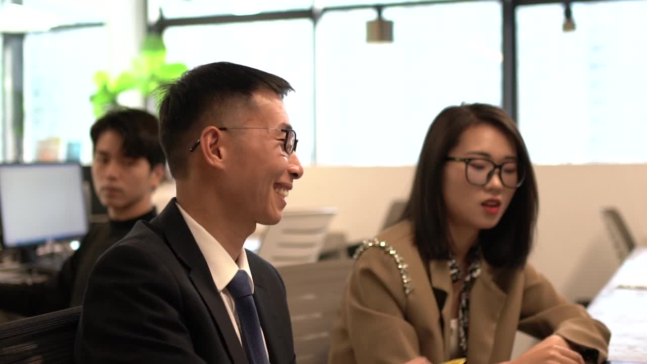 亚裔男性办公室职员，在后座听两位同事的对话视频下载