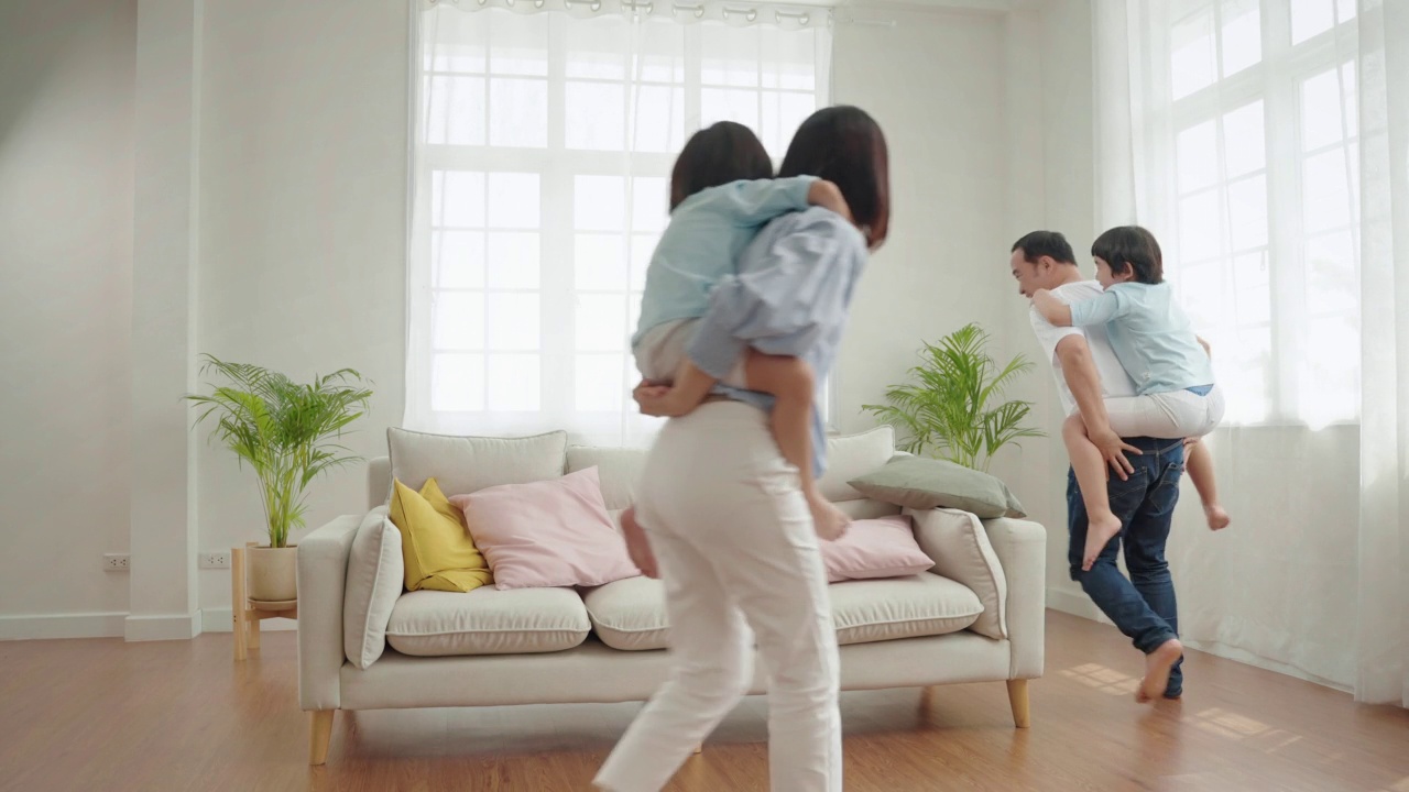 亚洲家庭正在房子里玩骑在肩上的游戏。视频素材