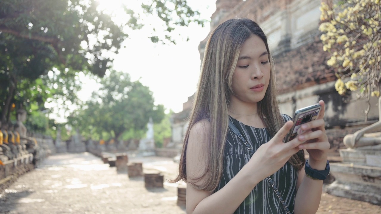 5G连接生活方式年轻的中年亚洲人幸福乐趣独自旅行女人探索冒险在大城府最著名的寺庙视频下载