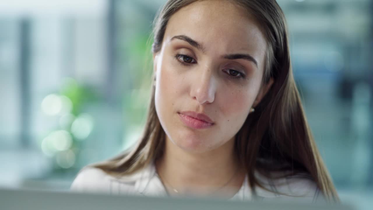 一个年轻的女商人在一间现代化的办公室里使用电脑，看起来很紧张视频素材