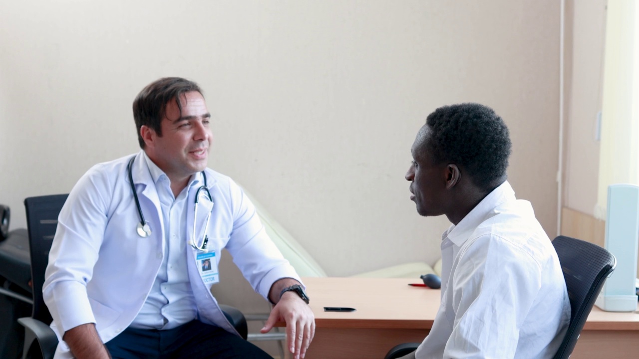 男性医生检查一名非洲男性手臂和肩膀疼痛。在诊所视频素材