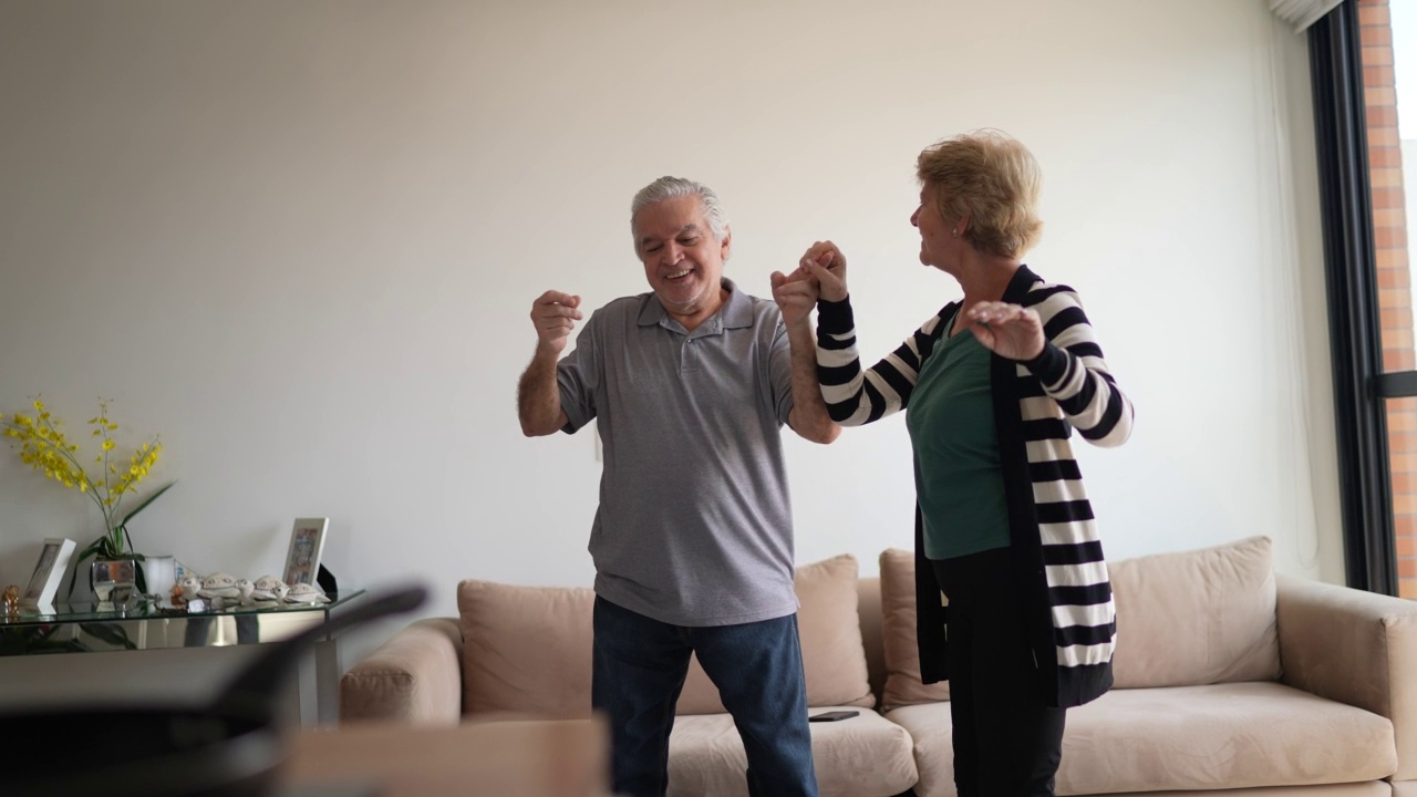 快乐的老年夫妇在家里跳舞视频素材