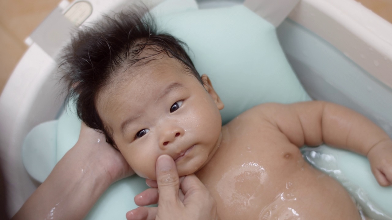 母亲给刚出生的男婴洗澡。视频素材