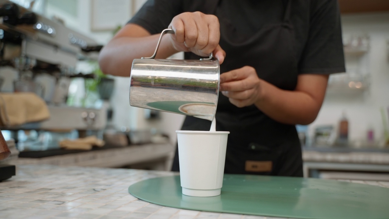年轻的亚洲女咖啡师在机器上煮咖啡视频素材