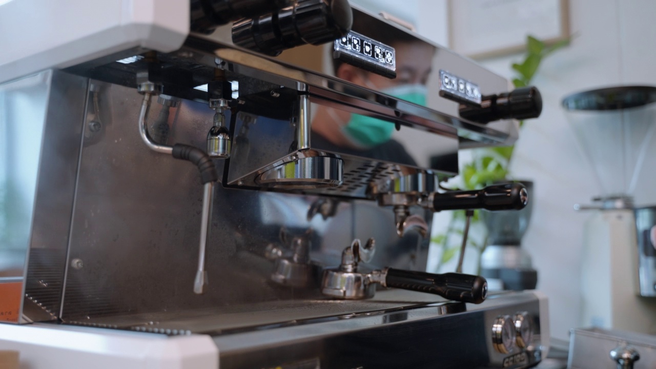 年轻的亚洲女咖啡师在机器上煮咖啡视频素材