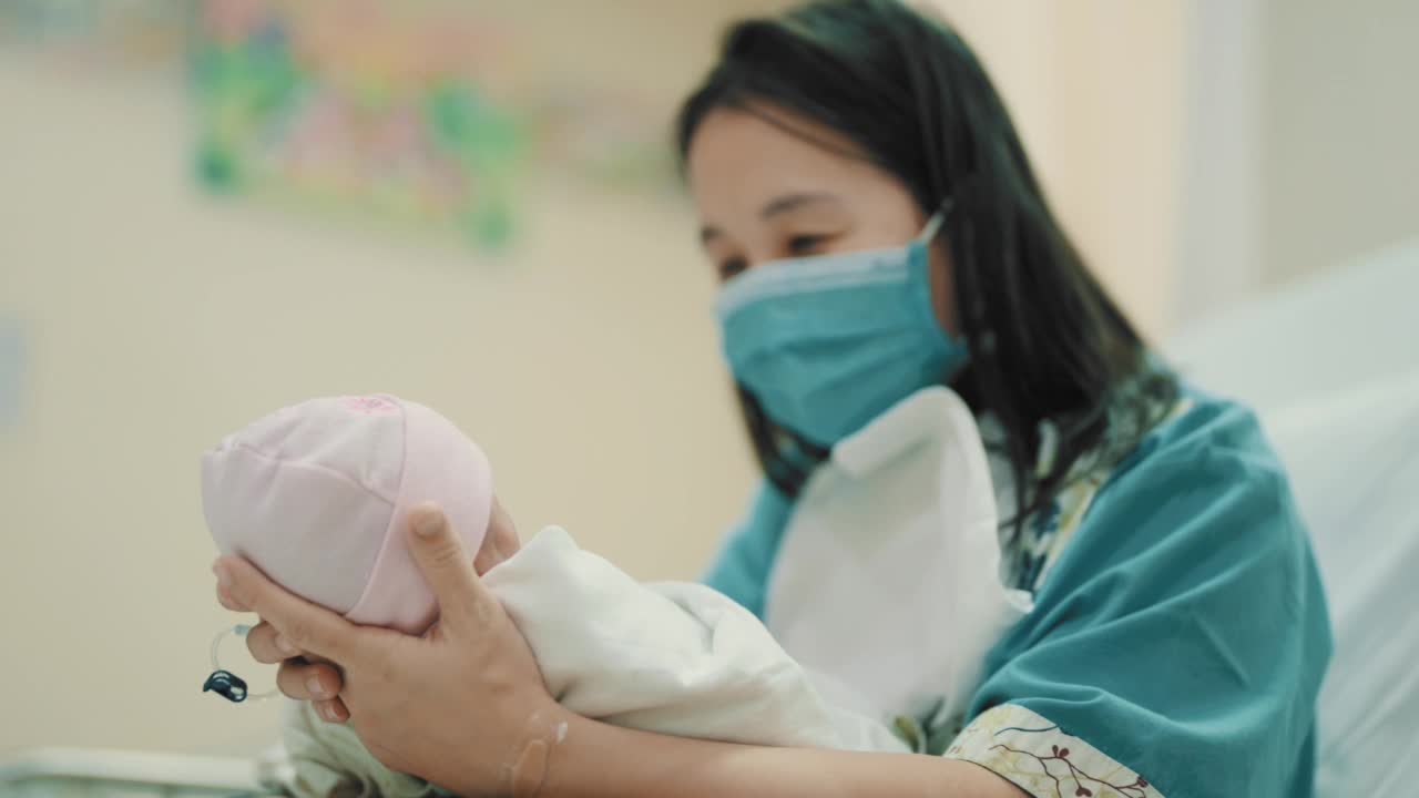 母亲抱着新生儿(0-1个月)在育婴室视频下载