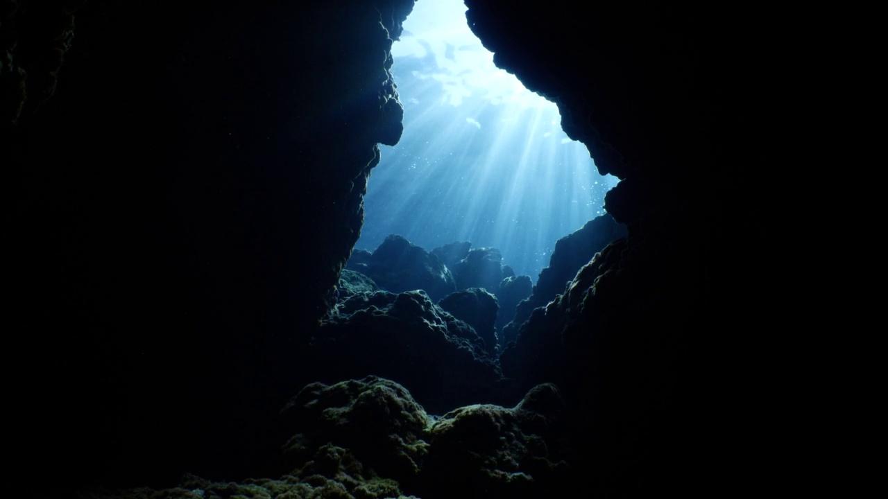 太阳光线，阳光光束和阳光在水下洞穴美丽的光风景在海洋潜水者看到在洞穴背景视频素材