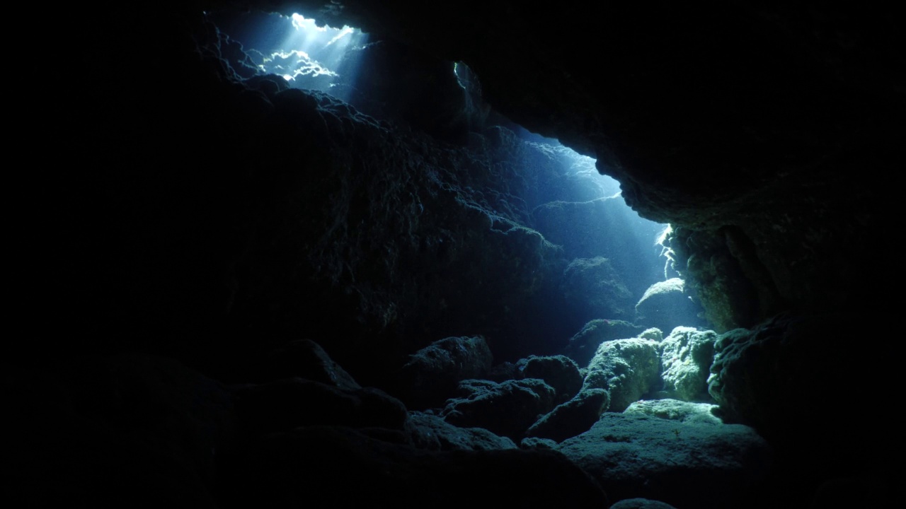 太阳光线，阳光光束和阳光在水下洞穴美丽的光风景在海洋潜水者看到在洞穴背景视频下载