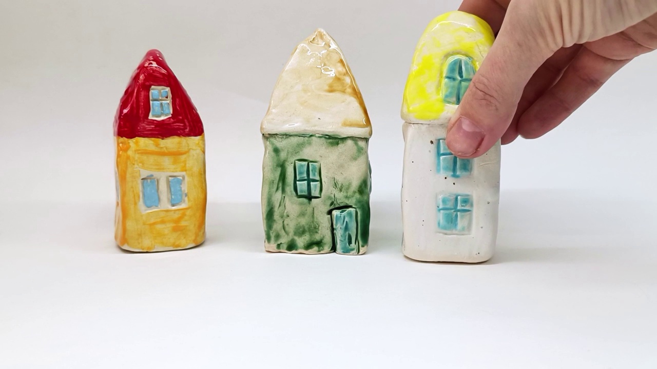 白色背景上五颜六色的玩具陶瓷房子视频下载