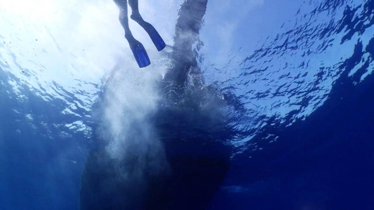 潜水者乘船潜入水中，欣赏海洋风光视频素材