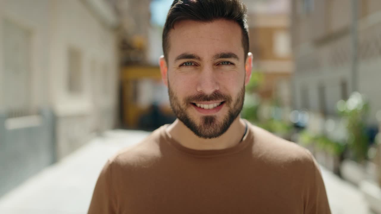 年轻的西班牙裔男子面带微笑，自信地拿着美元在街上视频下载