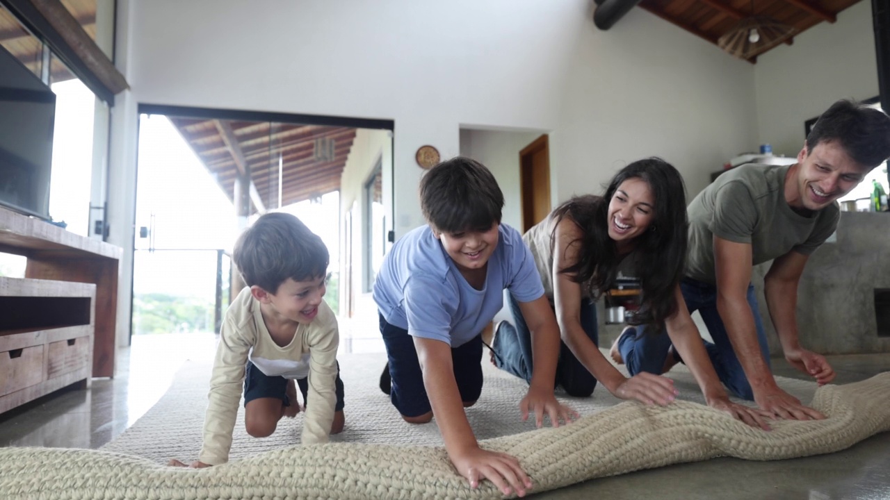 幸福的家庭在家里一起展开地毯视频素材