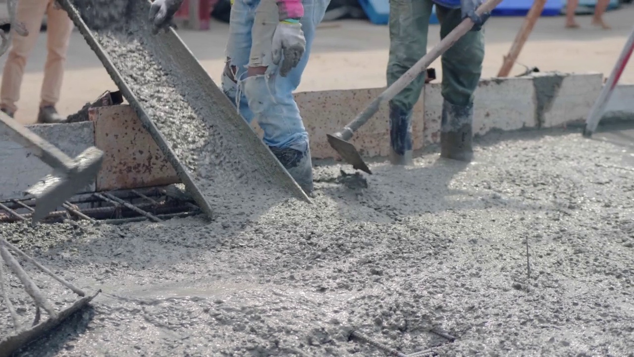 一名亚洲男子用泵将混凝土倒在地上。视频下载