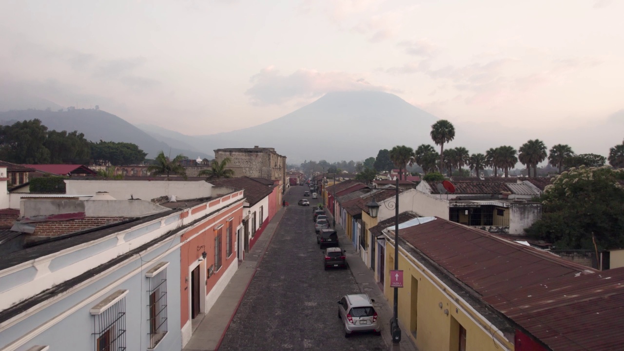 多云的一天，在危地马拉安提瓜岛，可以看到死气沉沉的阿瓜火山、鹅卵石街道和屋顶视频下载