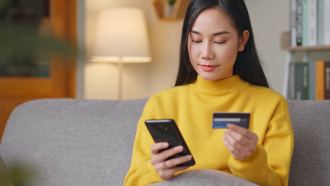 亚洲女性使用电话和信用卡在网上购物或信用卡支付视频素材