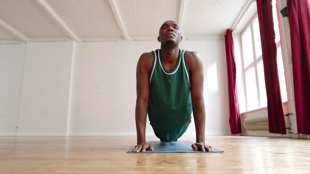 一名非洲男子在瑜伽课上做伸展运动视频素材