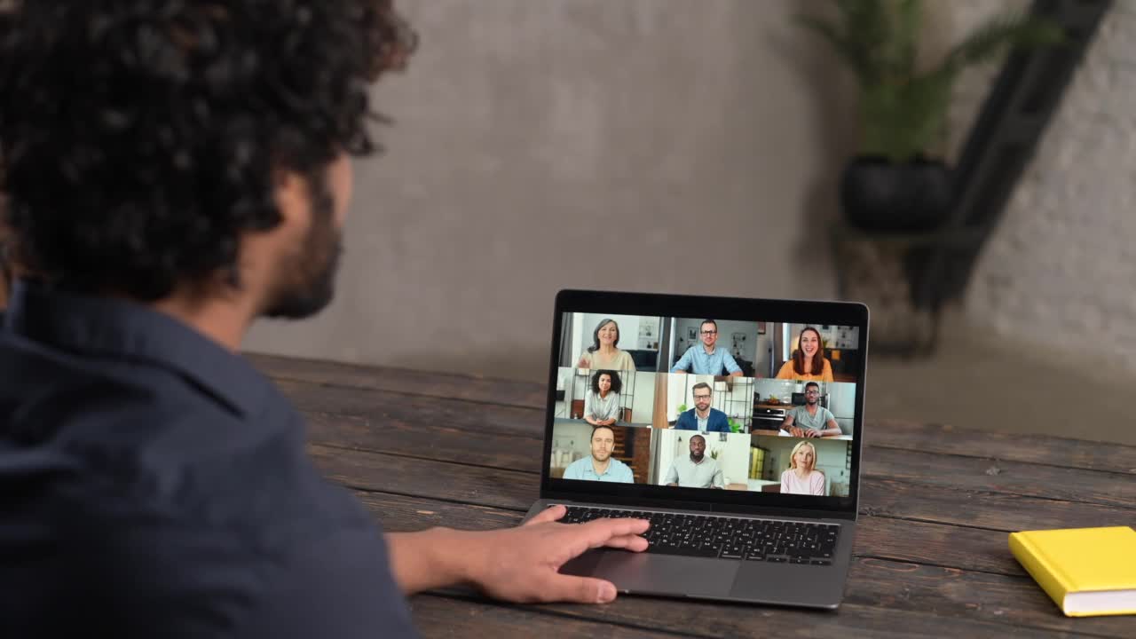一名男性员工使用笔记本电脑与不同的工作团队进行视频会议视频素材
