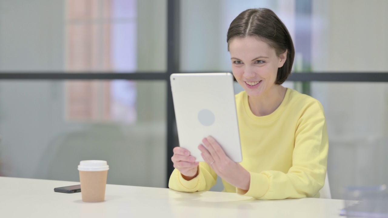 年轻女性在办公室用平板电脑进行视频通话视频素材