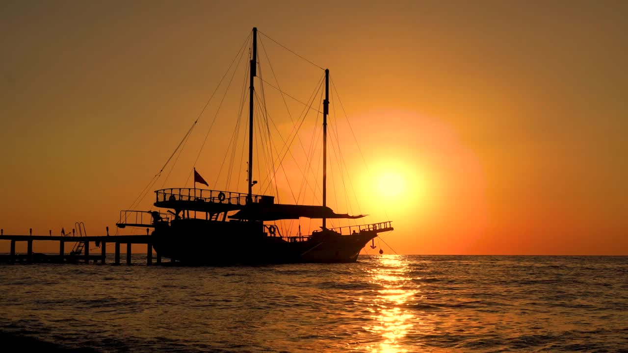 五颜六色的日落与帆船在海面上。反射在水面上的太阳落日海洋。海景，夏日和旅游度假的概念视频下载