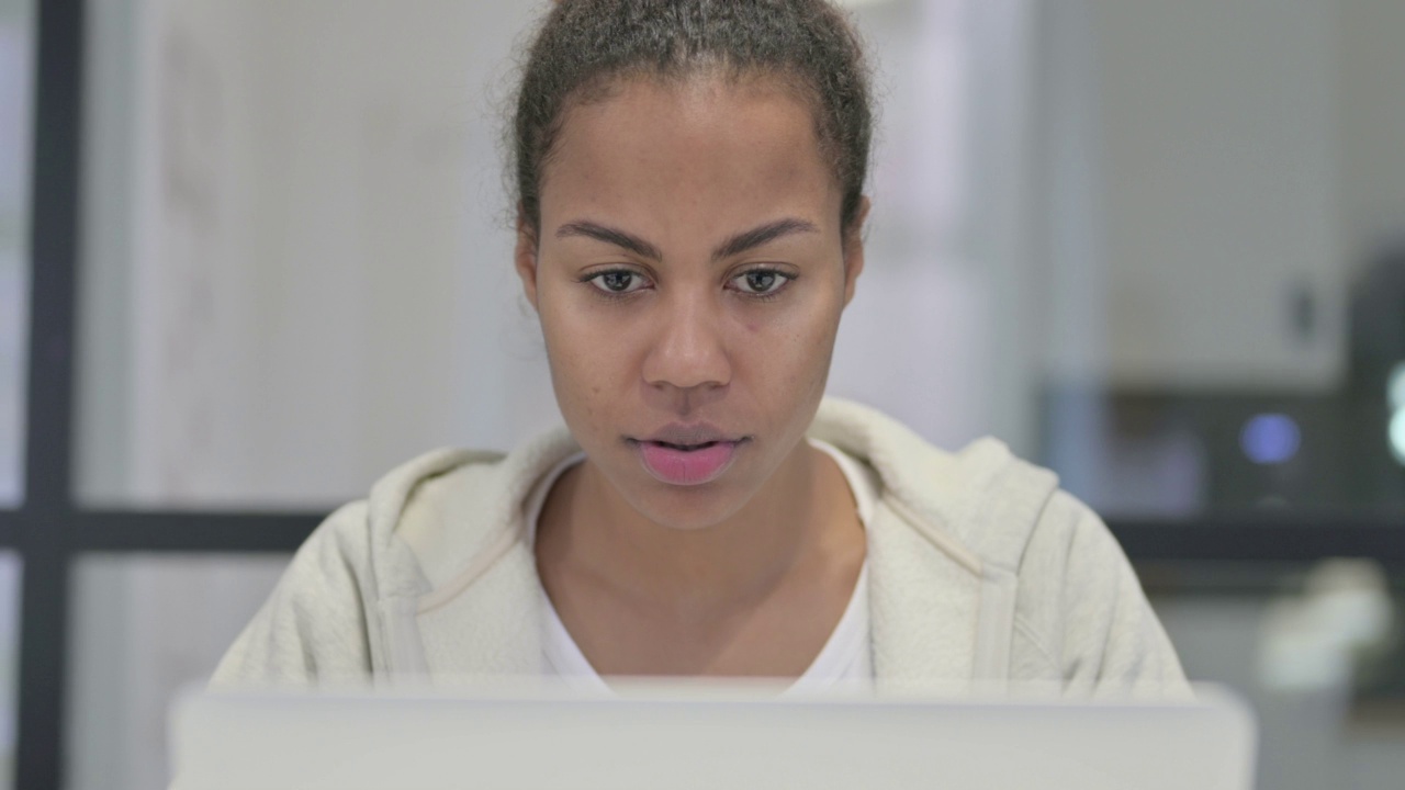 非洲妇女在笔记本电脑上工作的特写视频素材