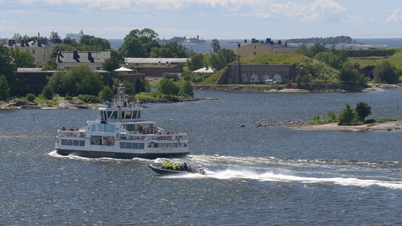 在赫尔辛基沿海岛屿附近，一艘快艇驶过一艘渡船。视频素材