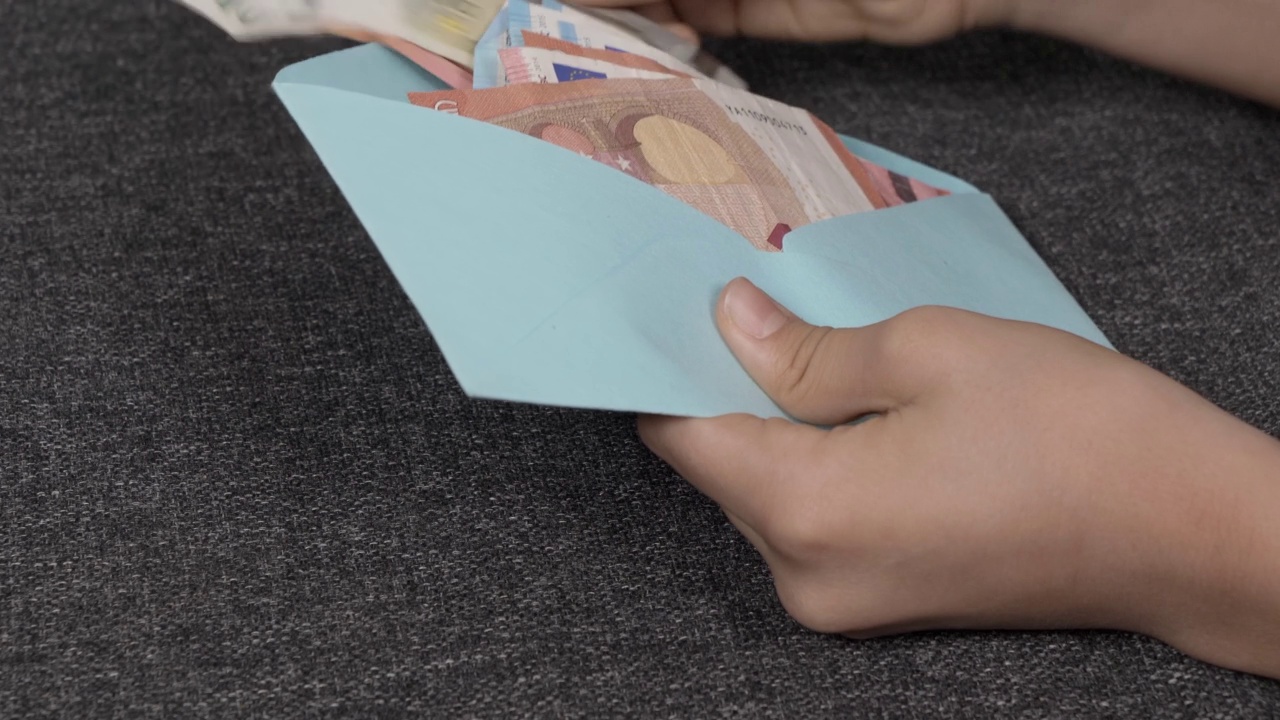 十几岁的男孩打开蓝色信封，检查，数了数几张欧元钞票。为孩子们准备礼物、储蓄、理财知识视频下载