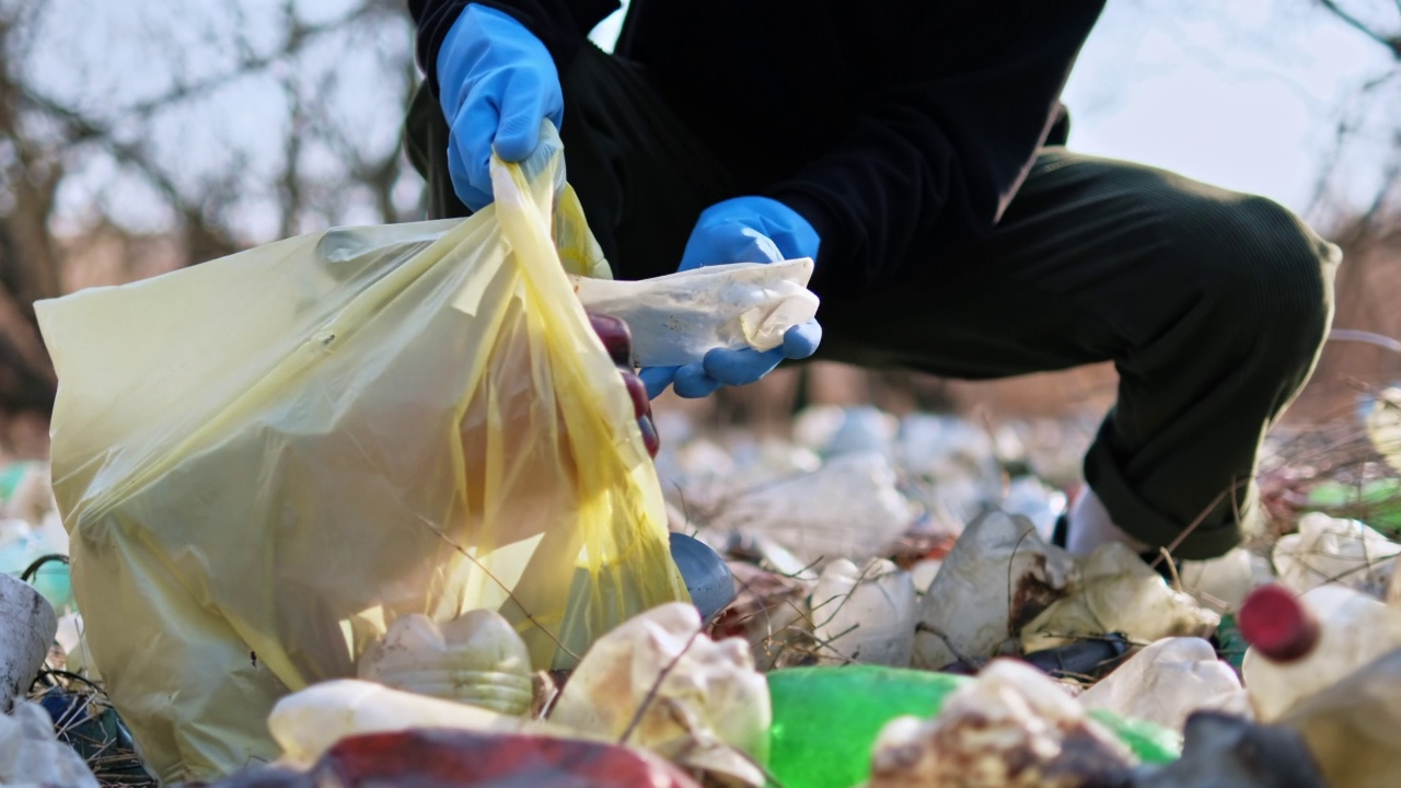 人们从大自然的地上收集散落的塑料瓶视频素材