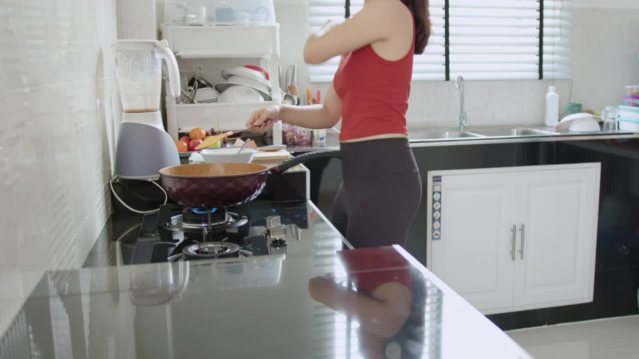 一位亚洲妇女在运动后做了一个煎蛋卷视频素材