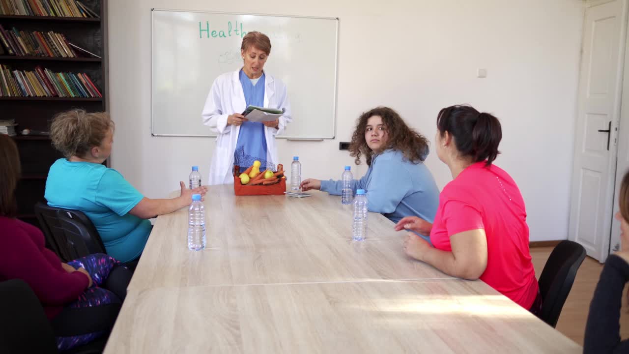一位营养学家正在教授一群女士关于健康饮食和锻炼的知识视频素材