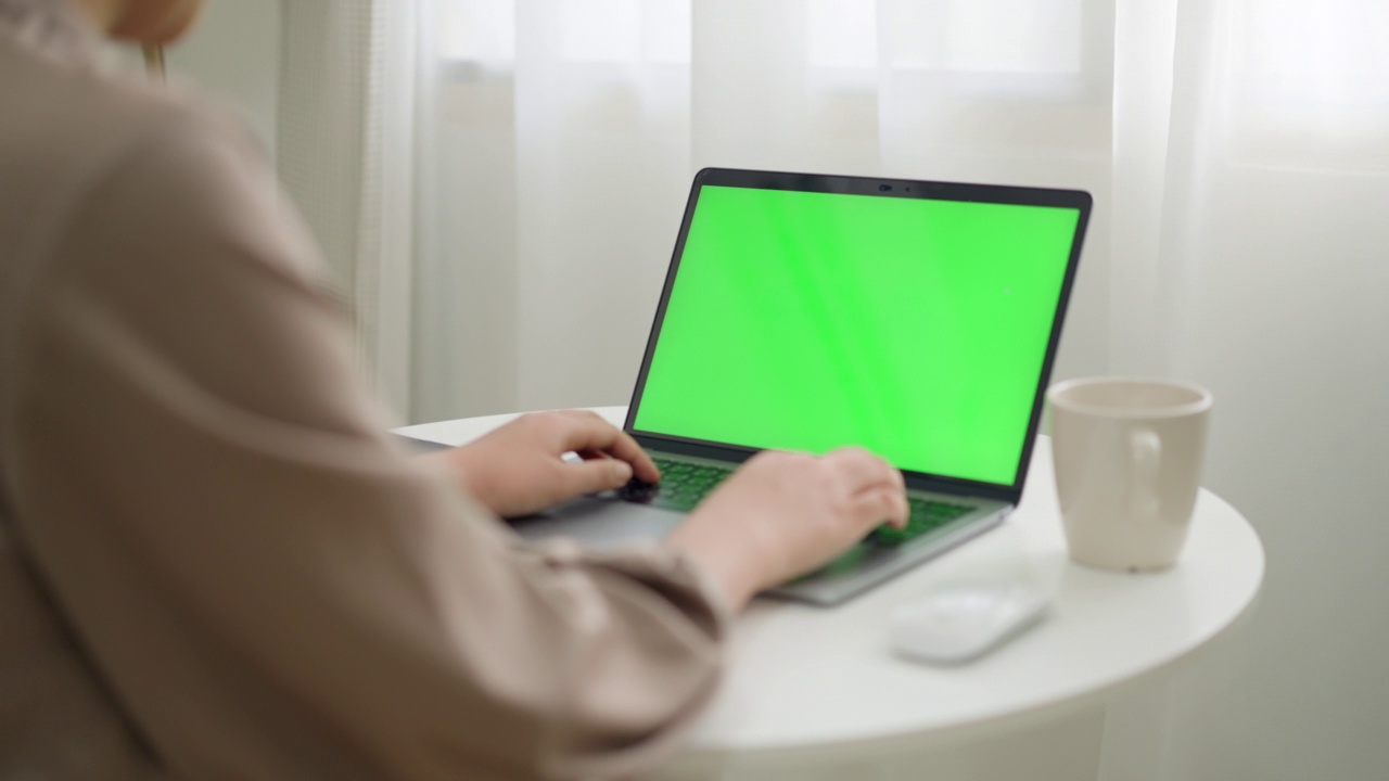 使用绿屏笔记本电脑的女人视频素材