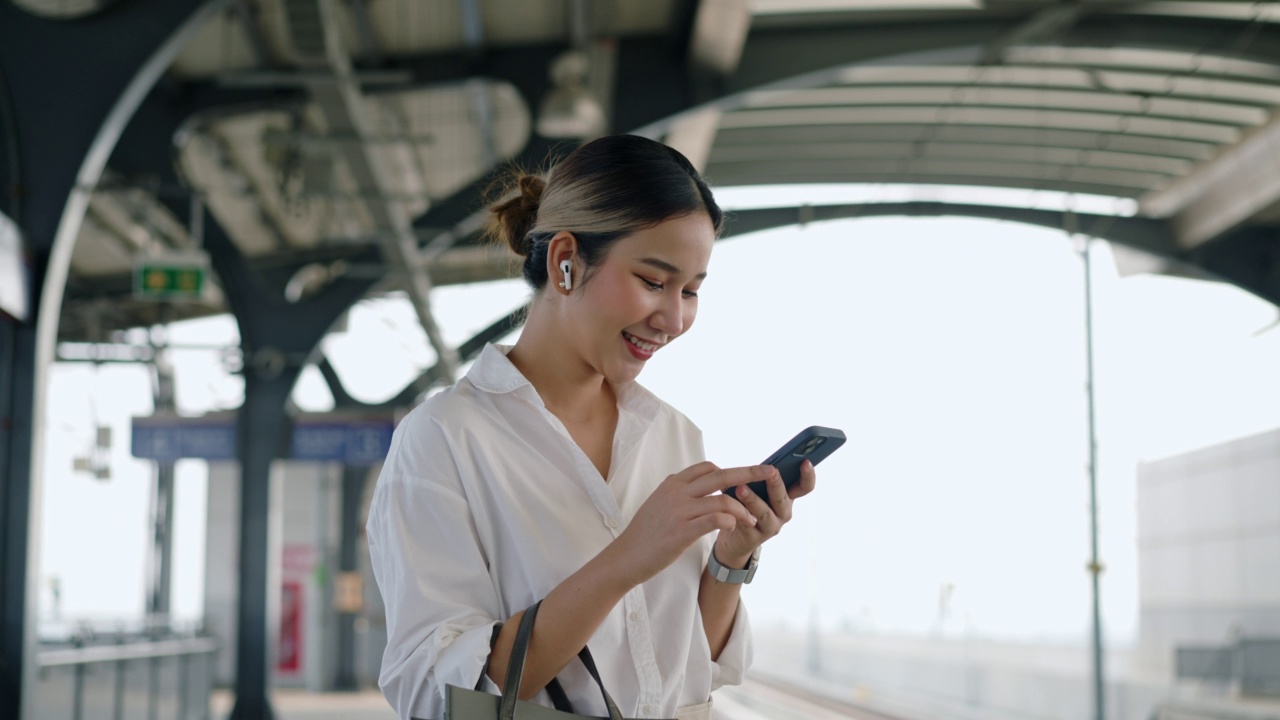 一名女子在等火车时用手机查询旅行信息视频素材