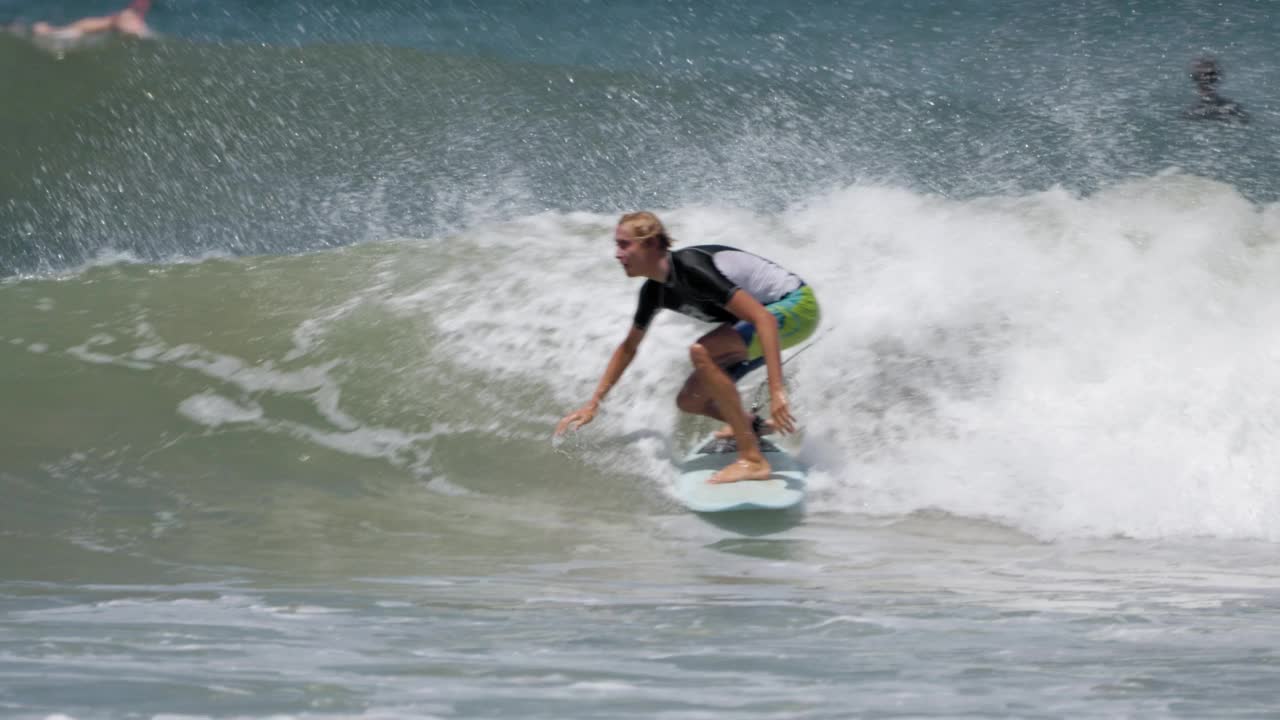 在哥斯达黎加，冲浪者在海浪上转弯视频下载