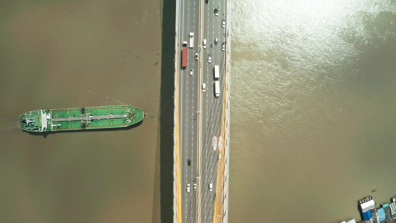 油船通过桥下道路到炼油厂进行运输或能源概念背景。视频素材
