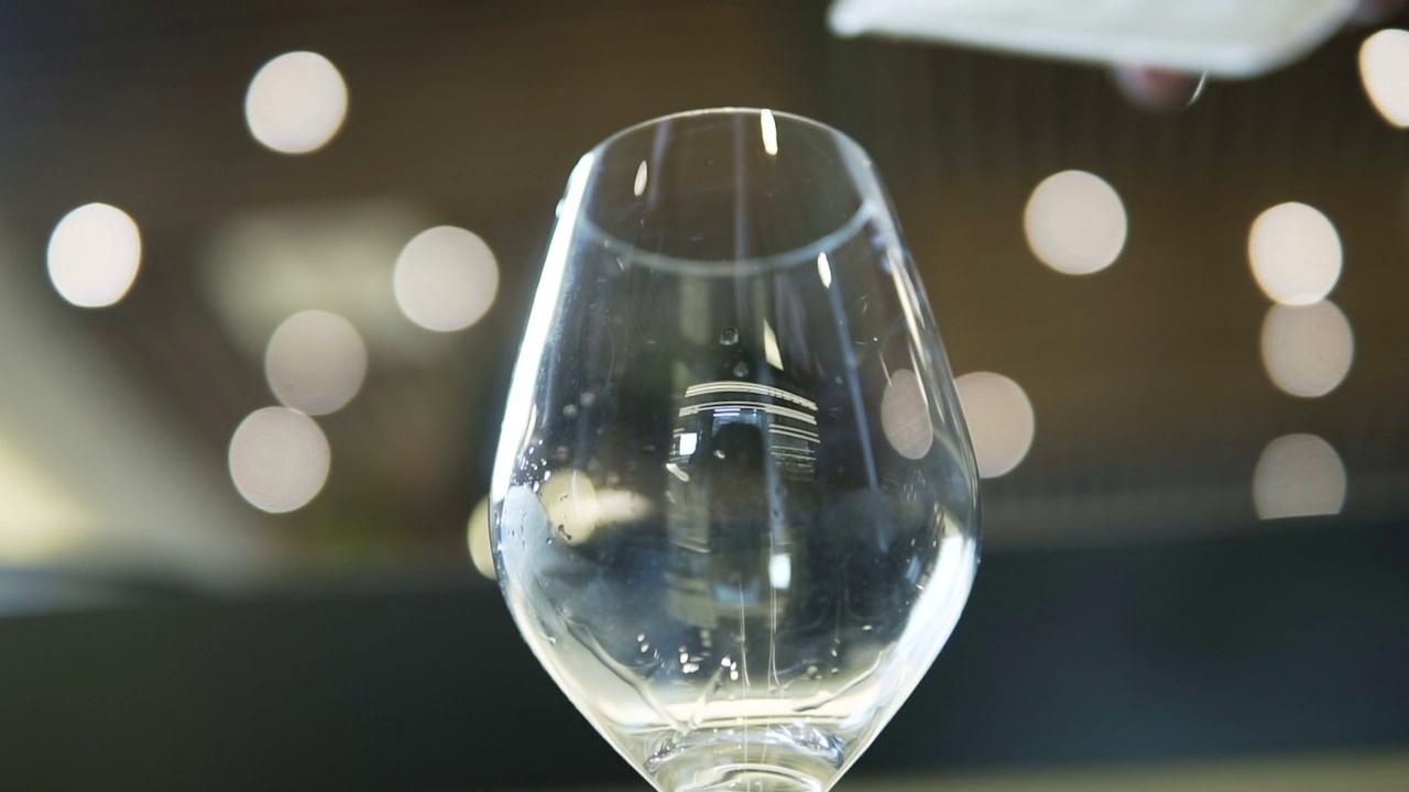 调酒师用慢动作向玻璃杯中加入冰块，在吧台制作鸡尾酒，stock video视频下载