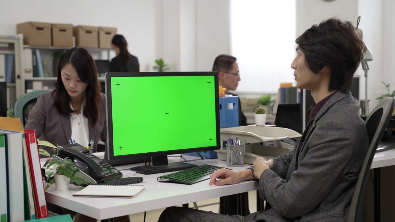 亚洲男性经理穿着西装，用手势交谈，同时在电脑上用公司的色度键绿色模型进行视频聊天视频下载