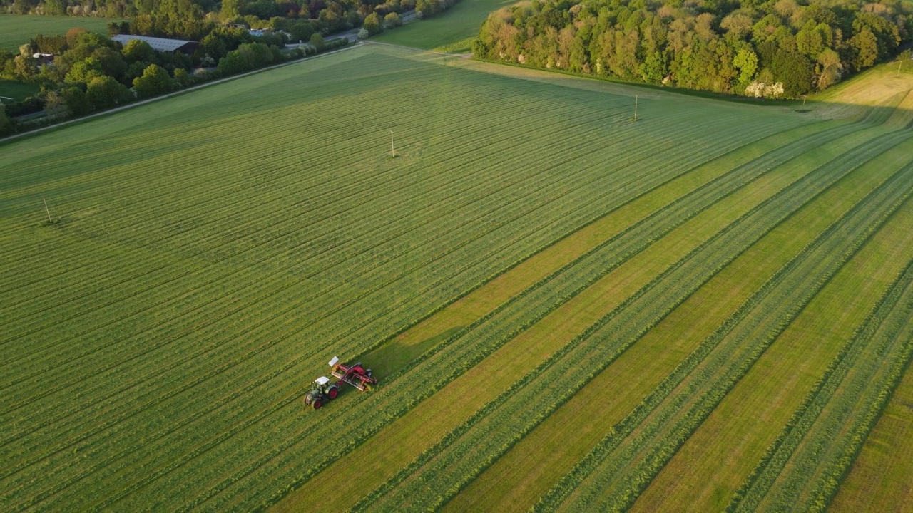 无人机拍摄的农民在拖拉机上耕作的农田，全景景观农田天空与云视频素材