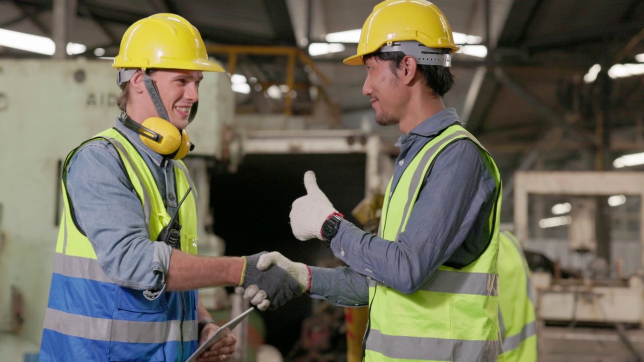 在检查完成品的质量控制后，工厂工人握手。握手之后，一组不同的工程师团队检查工厂的生产。视频素材