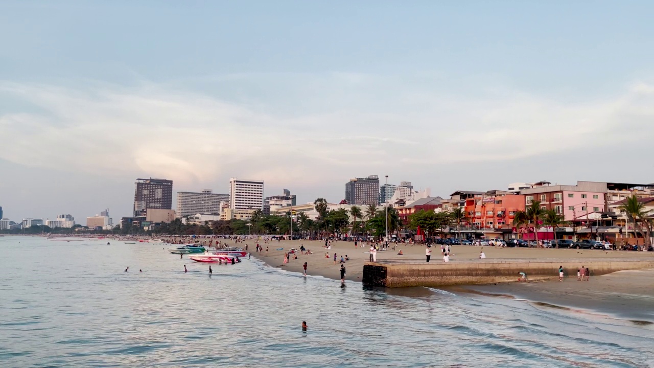 芭堤雅海滩日落创造了戏剧性的美丽天空反射穿过温和的波浪在海滨港口。为泰国旅游，度假，健康和健康营销主题建立异国情调的镜头和概念片视频素材