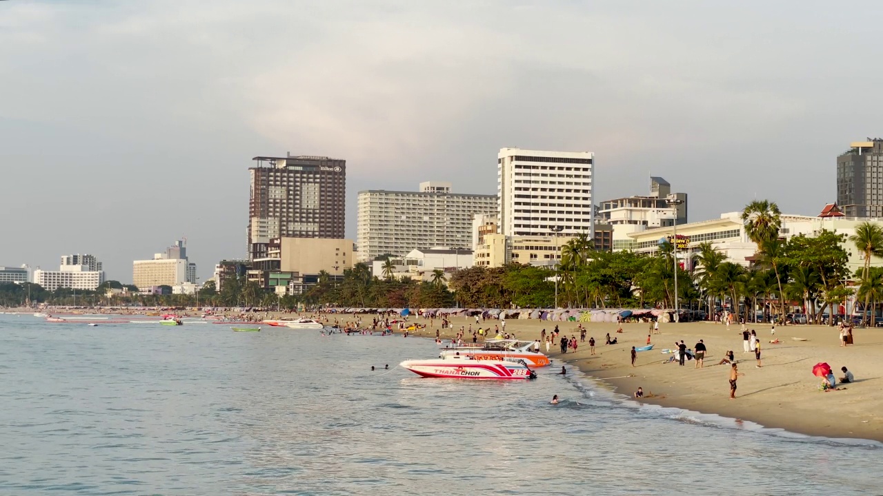 芭堤雅海滩日落创造了戏剧性的美丽天空反射穿过温和的波浪在海滨港口。为泰国旅游，度假，健康和健康营销主题建立异国情调的镜头和概念片视频素材