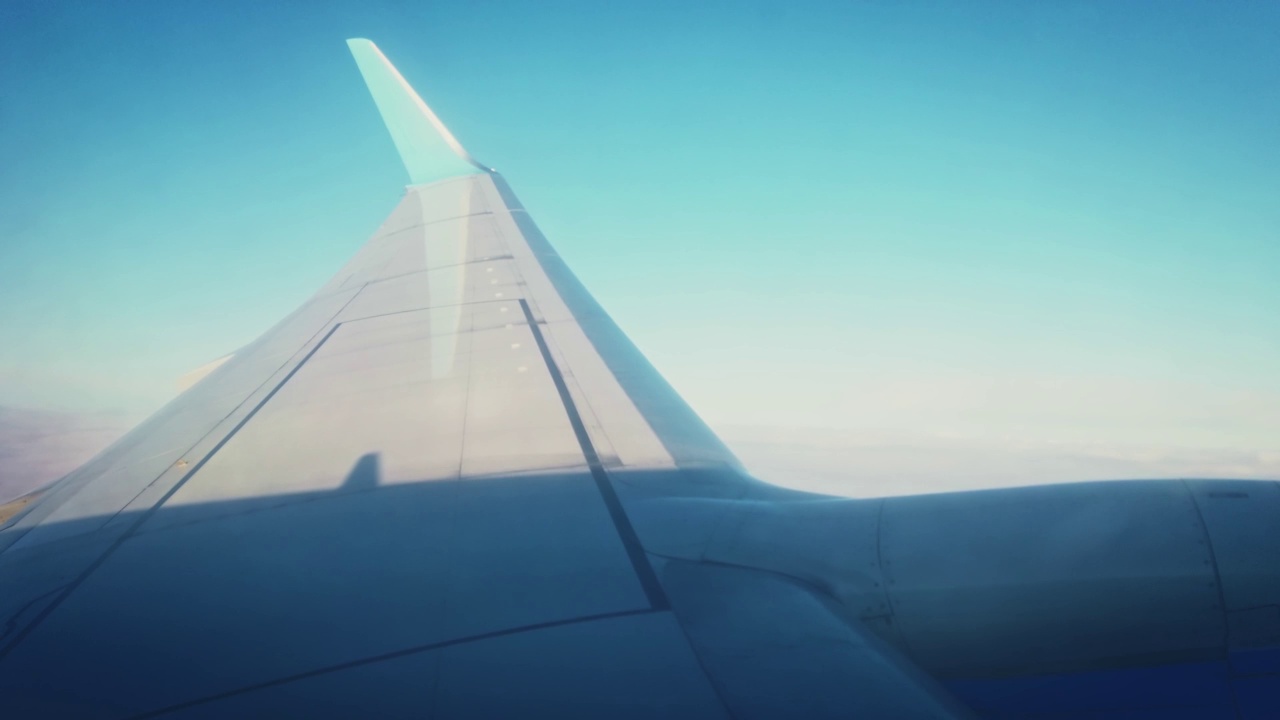 从飞机的窗口在云上飞行。阴影落在翅膀上视频素材