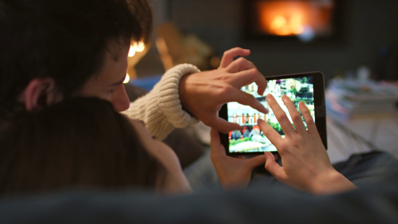 一对情侣看数码平板上的照片，拥抱在一起的4k视频视频素材
