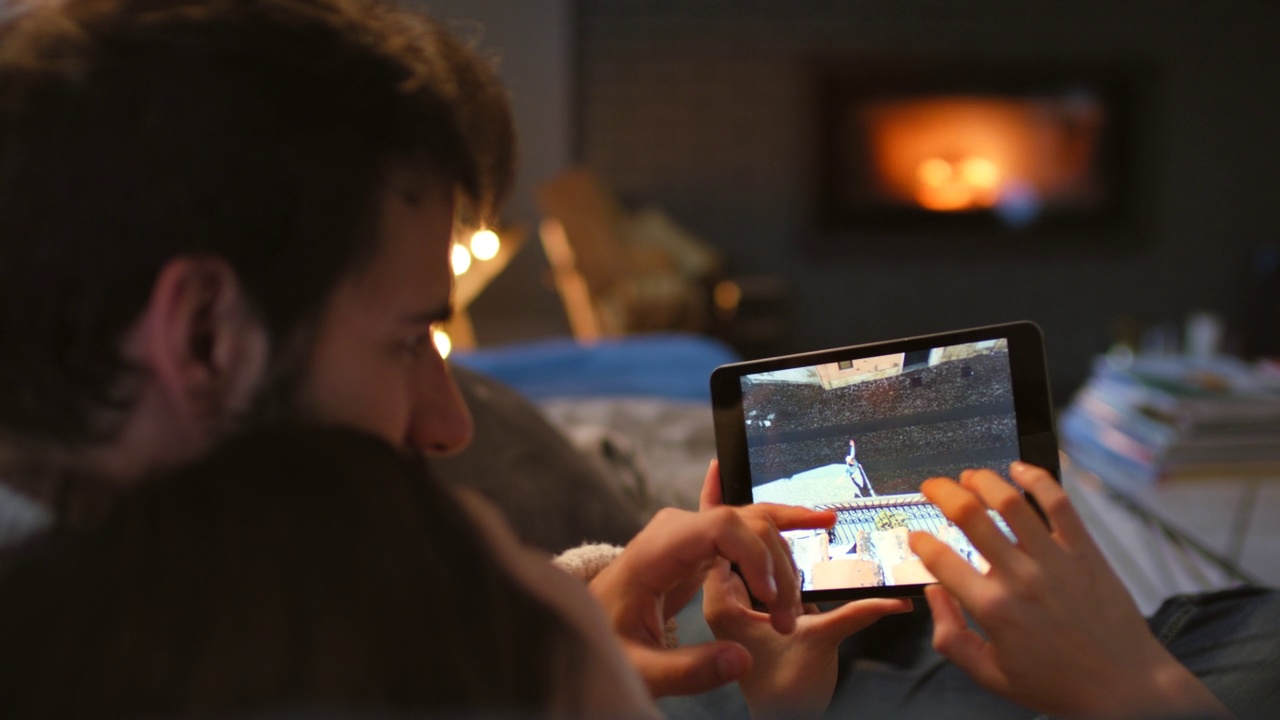一对情侣看数码平板上的照片，拥抱在一起的4k视频视频素材