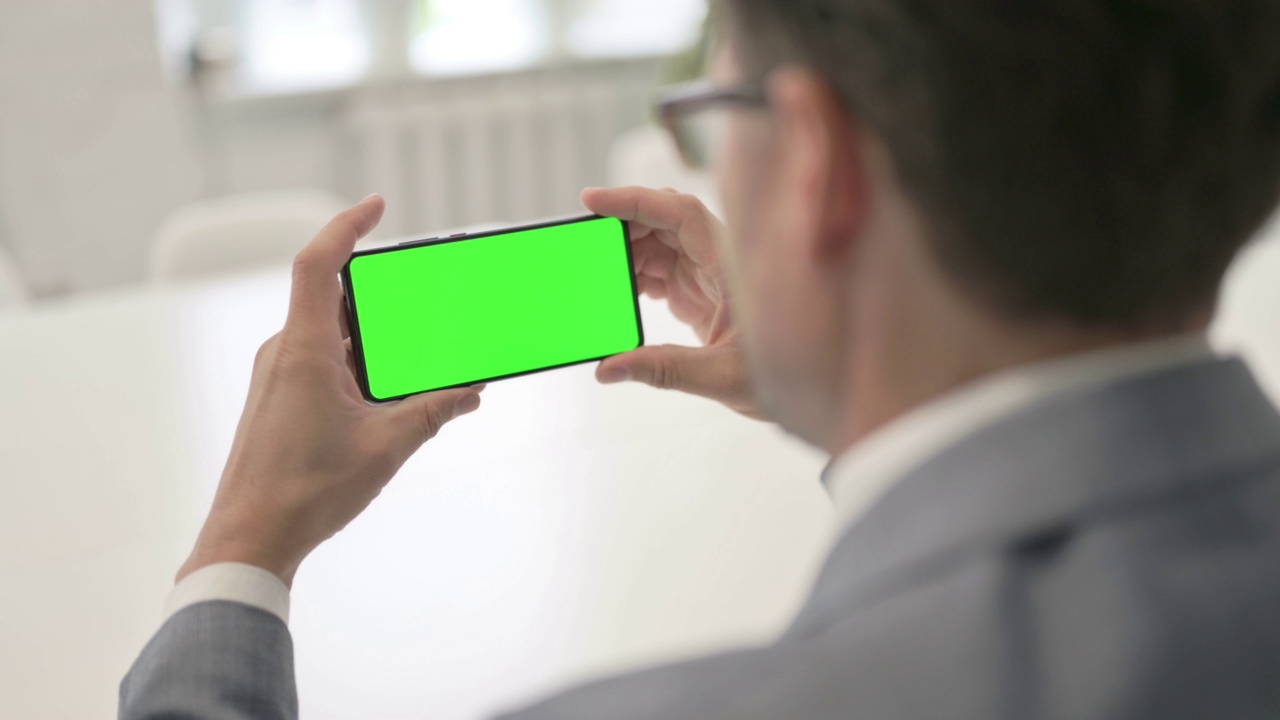 看绿色屏幕的智能手机视频素材