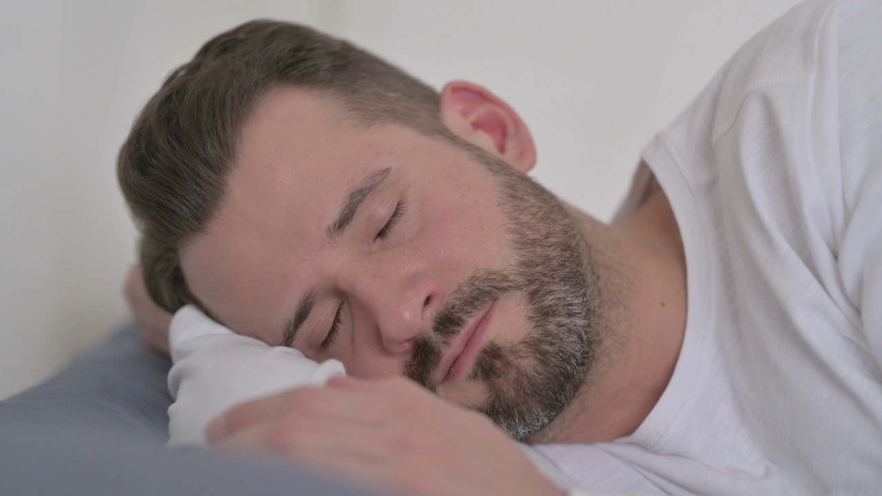 男子在床上睡觉时咳嗽视频素材