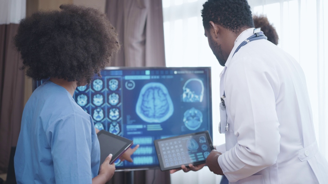 医生团队正在观看数字平板电脑上的大脑扫描显示。视频素材